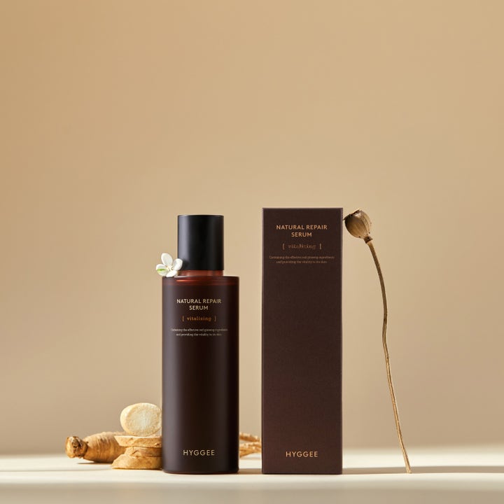 Hyggee Natural Repair Serum 120 ml reparerande serum i brun flaska och ask bredvid skivad ginsengrot.