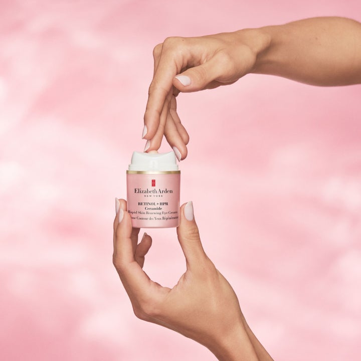 Elizabeth Arden Ceramide Retinol + Hpr 15 ml förnyande ögonkräm i rosa burk med pump som hålls i händerna.