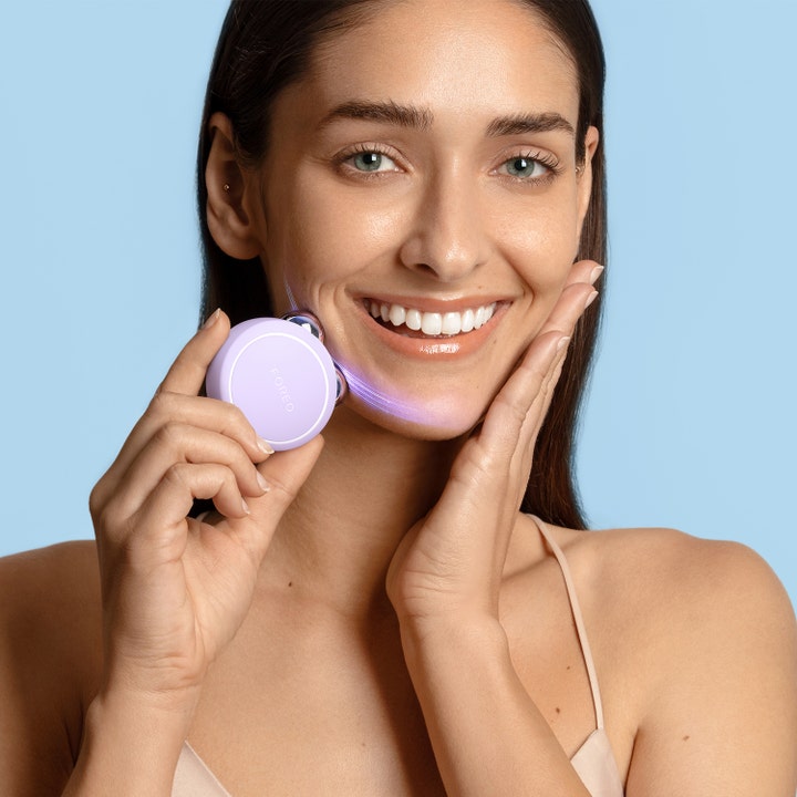FOREO BEAR 2 go Lavender 1 st beauty tech för fastare hud där en kvinna använder den lila enheten längs käklinjen