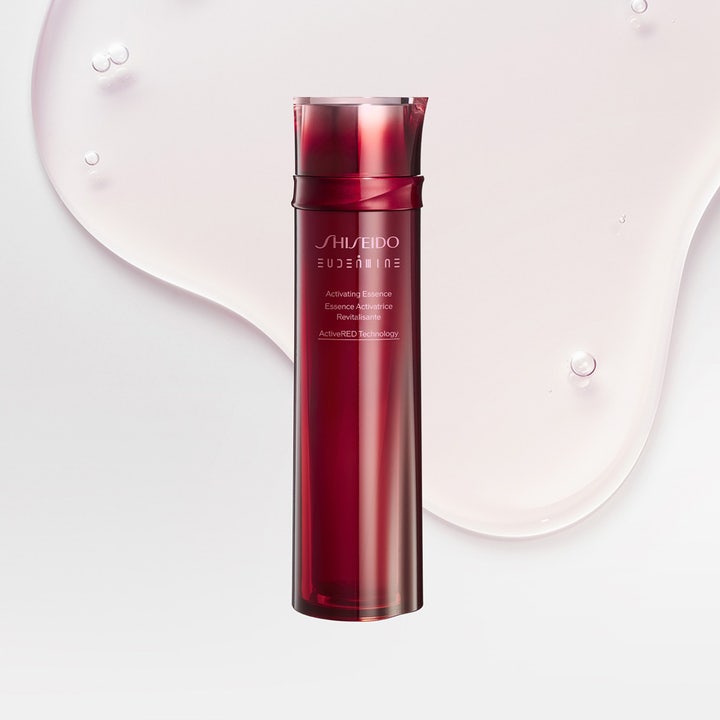 Shiseido Eudermine Activating Essence 150 ml aktiverande essence hudvård i röd flaska på en vattnig textur