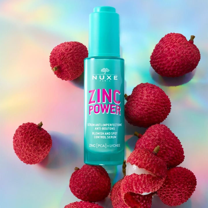 Nuxe Zinc Power Blemish And Spot Control Serum 30 ml hudserum mot orenheter i turkos flaska omgiven av litchifrukter