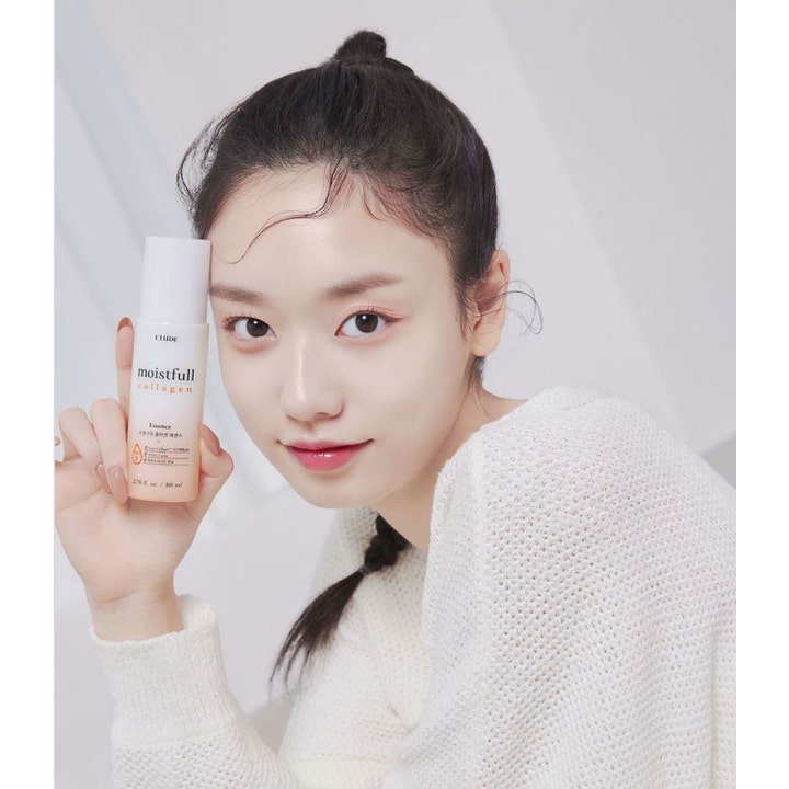 Etude Moistfull Collagen Essence 80 ml återfuktande serum ger lyster i persikofärgad flaska som hålls av kvinna