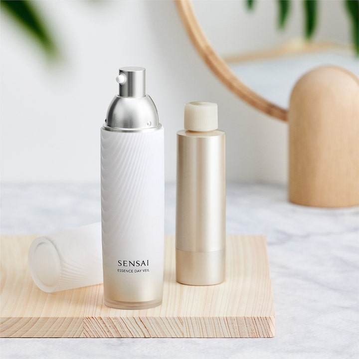 Sensai Essence Day Veil 40 ml fuktgivande dagkräm för ansiktet i vit texturerad flaska med silverpump på trä.