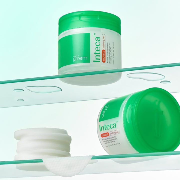 Make Prem Inteca Trouble Soothing Pads 70 st lugnande ansiktspads i vit burk med grönt lock och en stapel mjuka pads.