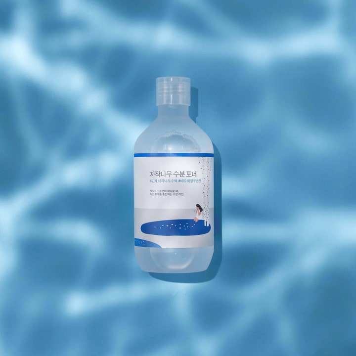 Round Lab Birch Juice Moisturizing Toner 300 ml återfuktande björksav ansiktsvatten i flaska mot blå vattenreflektioner