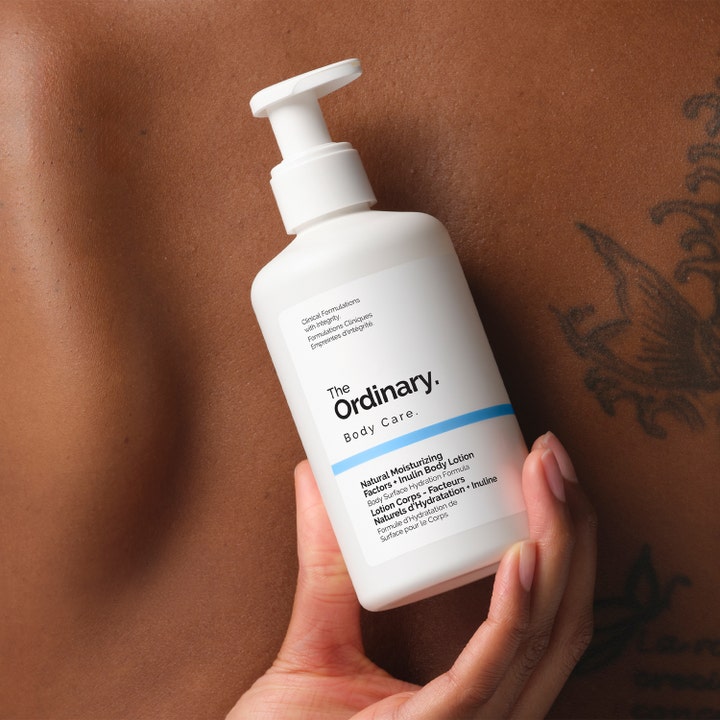 The Ordinary NMF + Inulin Body Lotion 240 ml minimalistisk återfuktande kroppskräm i vit pumpflaska mot hud.