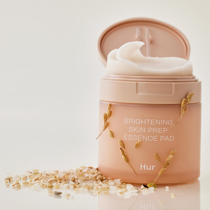 House of Hur Brightening Skin Prep Essence Pad 140 ml lystergivande hudvård i persikofärgad burk med vita pads och ris.