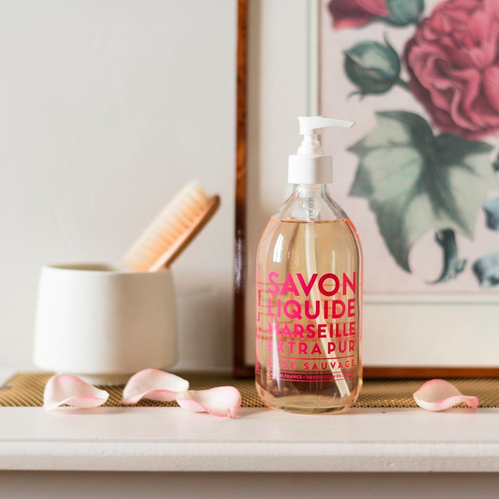 Compagnie de Provence Liquid Marseille Soap Wild Rose 495 ml i genomskinlig glasflaska med vit pump i badrumsmiljö