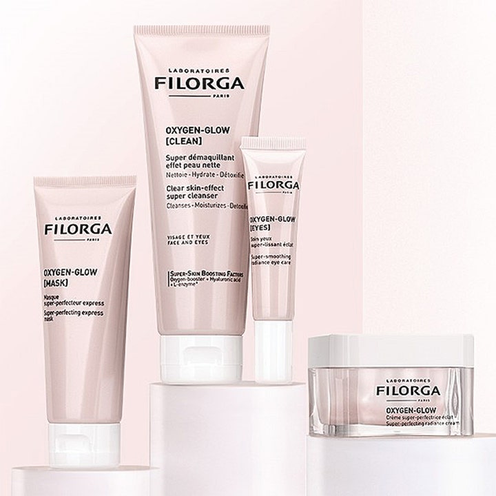 Filorga Oxygen-Glow Cream 50 ml ansiktskräm för glödande hy i glasburk bredvid matchande rosa tuber i samma serie.