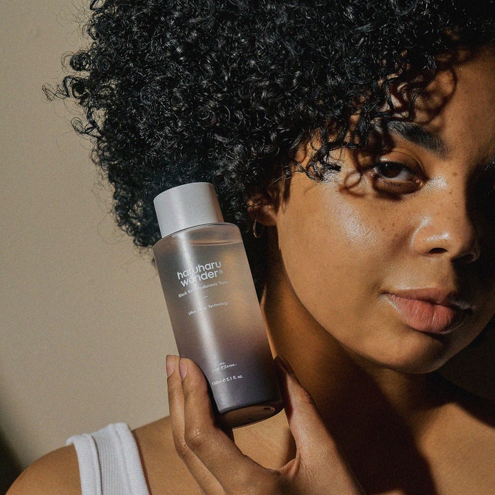 haruharu wonder Black Rice Hyaluronic Toner 150 ml återfuktande svart ris ansiktsvatten i tonad flaska i en persons hand
