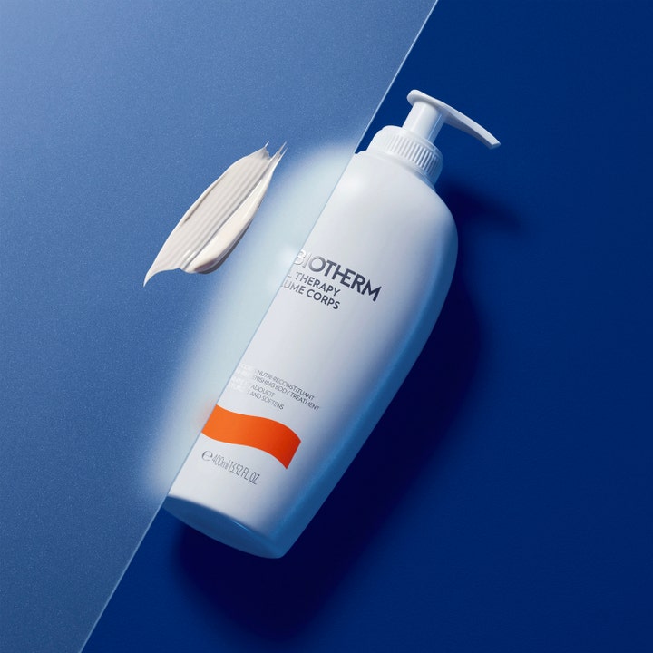 Biotherm Baume Corps Oil Therapy 400 ml djupnärande hudvård i vit pumpflaska med krämig textur på blå bakgrund