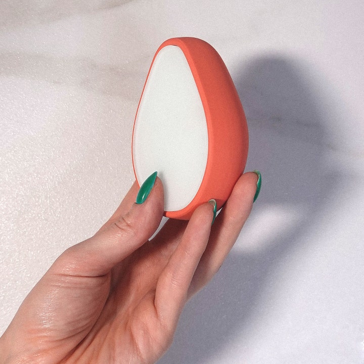 ANSWR Exfoliating Hair Removal Drop 1 st för hårborttagning och len hud, korallfärgad produkt som hålls i en hand.