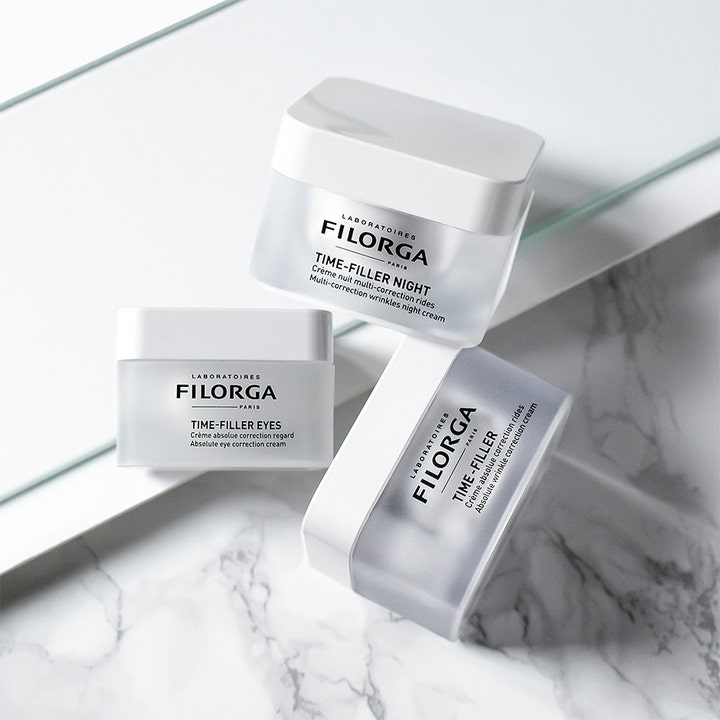 Filorga Time-Filler Night 50 ml anti-rynk nattkräm i frostade burkar på en elegant marmoryta med speglar.