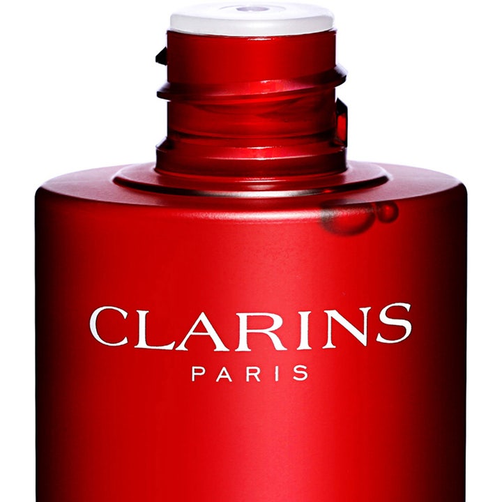 Clarins Super Restorative Treatment Essence 200 ml antiaging ansiktsessens i röd flaska med vit logotyp
