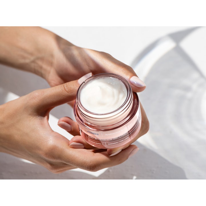 KORRES Apothecary Wild Rose 40 ml fuktgivande vitamin C hudvård i en rosa glasburk som hålls i händerna.