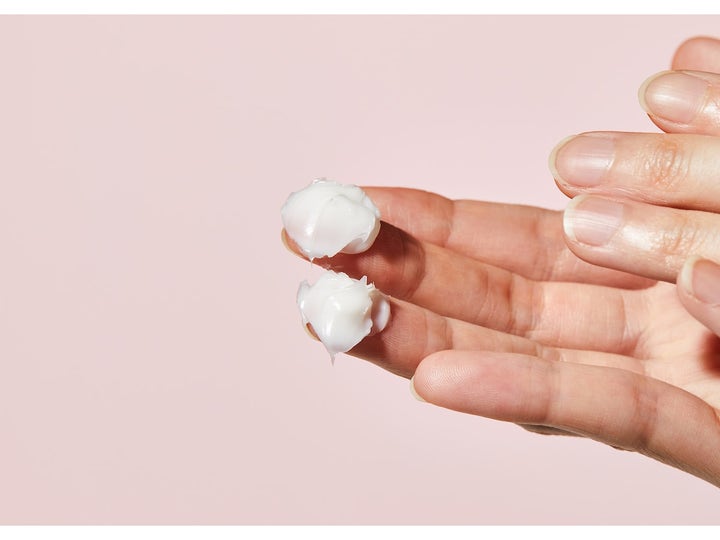 COSRX Balancium Comfort Ceramide Cream 80 ml återfuktande ceramidkräm med fyllig vit konsistens på två fingertoppar
