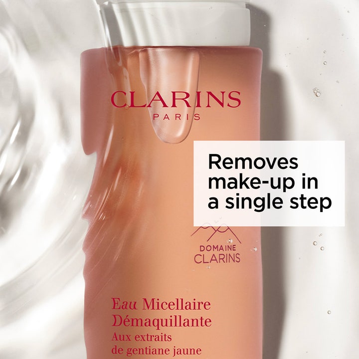 Clarins Cleansing Micellar Water 200 ml lugnande mild sminkborttagning i rosa flaska omgiven av klara vattenstänk.