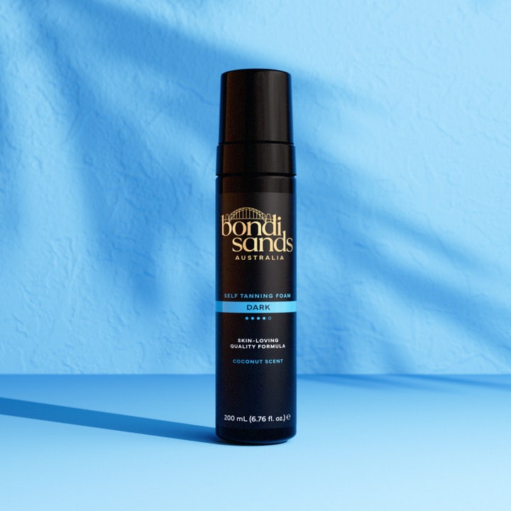 Bondi Sands Self Tanning Foam Dark 200 ml brun utan sol mousse bondi sands ger mörk ton i svart flaska mot blå fond.