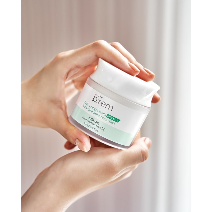 Make Prem Safe Me. Relief Moisture Cream 12 80 ml återfuktande ansiktskräm med pH 5.5 i vit burk som hålls i händerna.