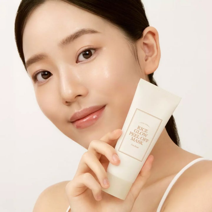 I'm from Rice Glow Peel Off Mask 70 g lystergivande ansiktsmask i vit tub som hålls av kvinna med strålande hy.