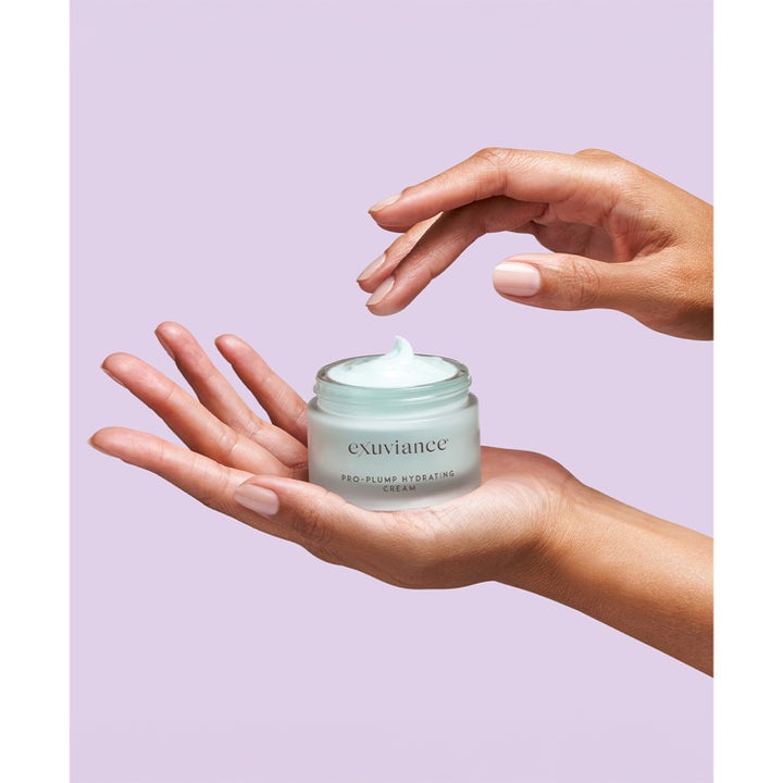 Exuviance Pro-Plump Hydrating Cream 45 g återfuktande nattkräm med ljusblå formula i glasburk som hålls i händerna.