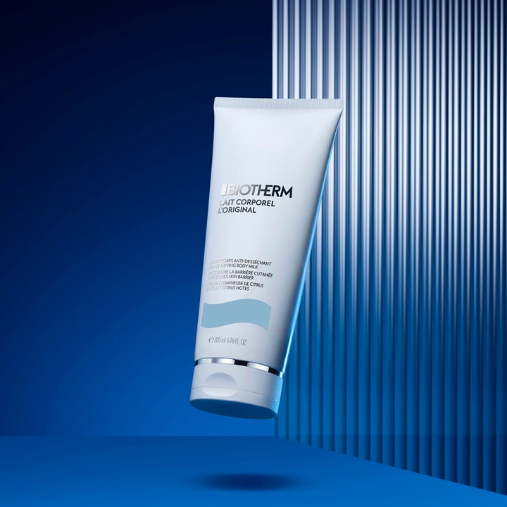Biotherm Lait Corporel 200 ml anti-uttorkande kroppslotion i vit tub mot en blå bakgrund med ränder.
