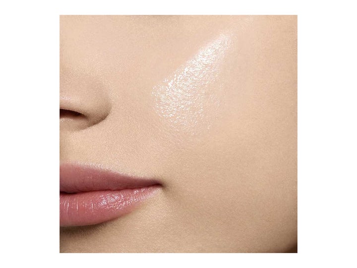 Clarins Blue Orchid Face Treatment Oil 30 ml lyxig naturlig ansiktsolja applicerad på en kind för lyster