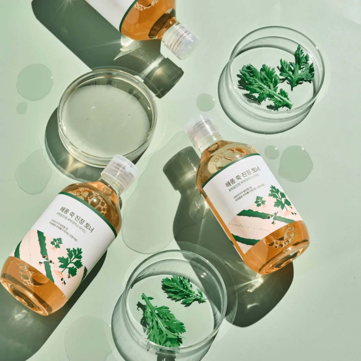 Round Lab Mugwort Calming Toner 300 ml lugnande ansiktsvatten i flaskor omgivna av gröna gråboblad